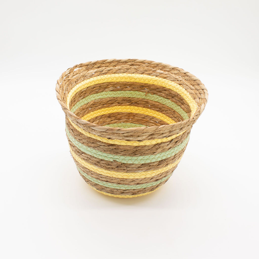 Woven basket with yellow and green stripes on a white background