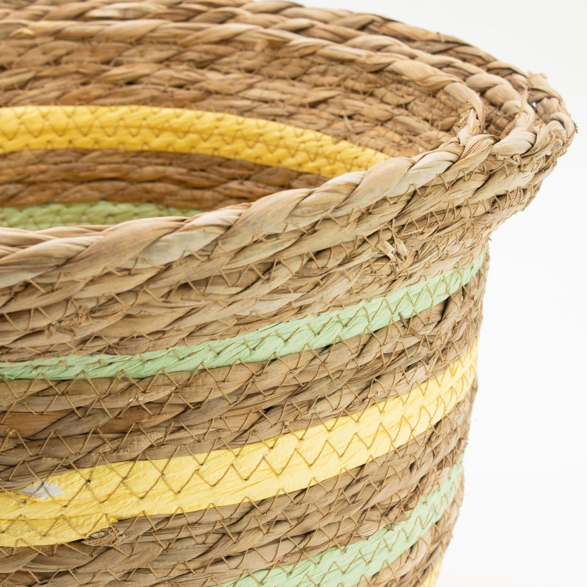 Woven basket with yellow and green stripes on a white background