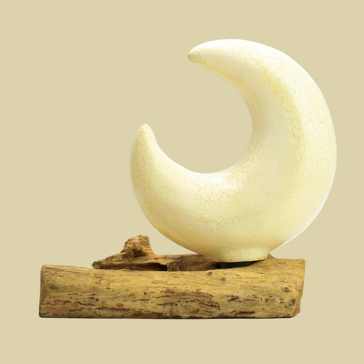 Decorative moon sculpture on a wooden base with a white background
