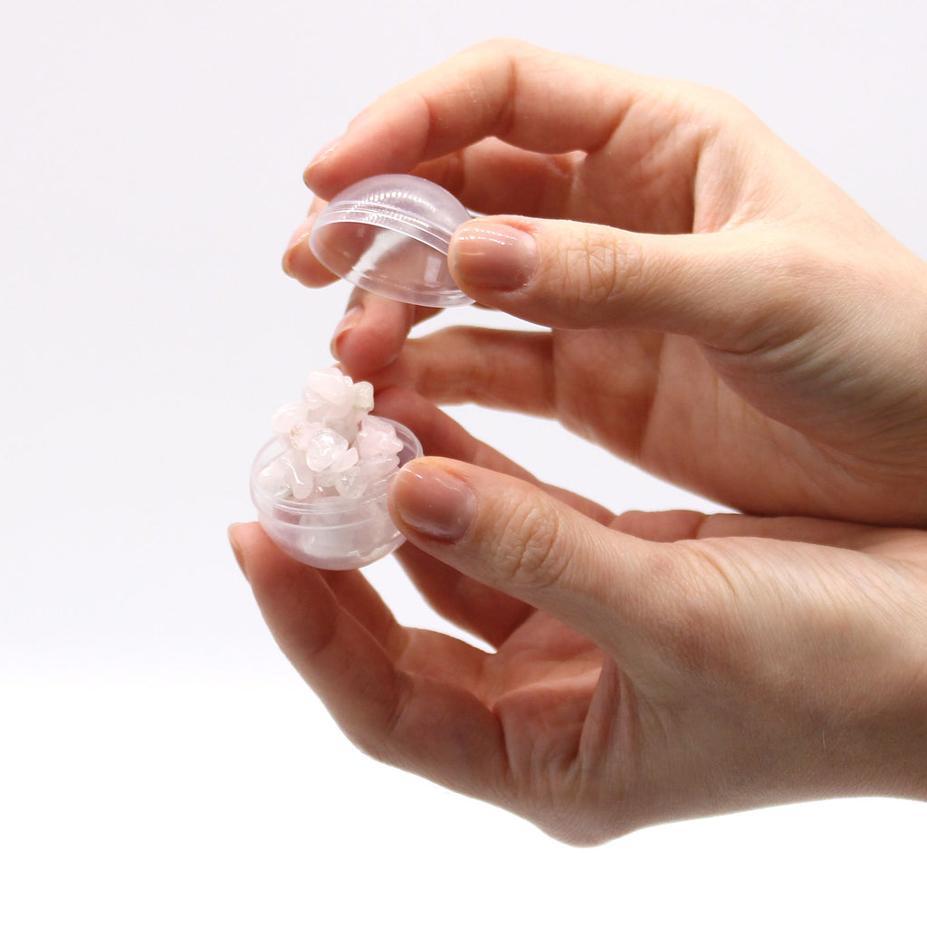 Hand holding a small transparent container with a white substance on a light background