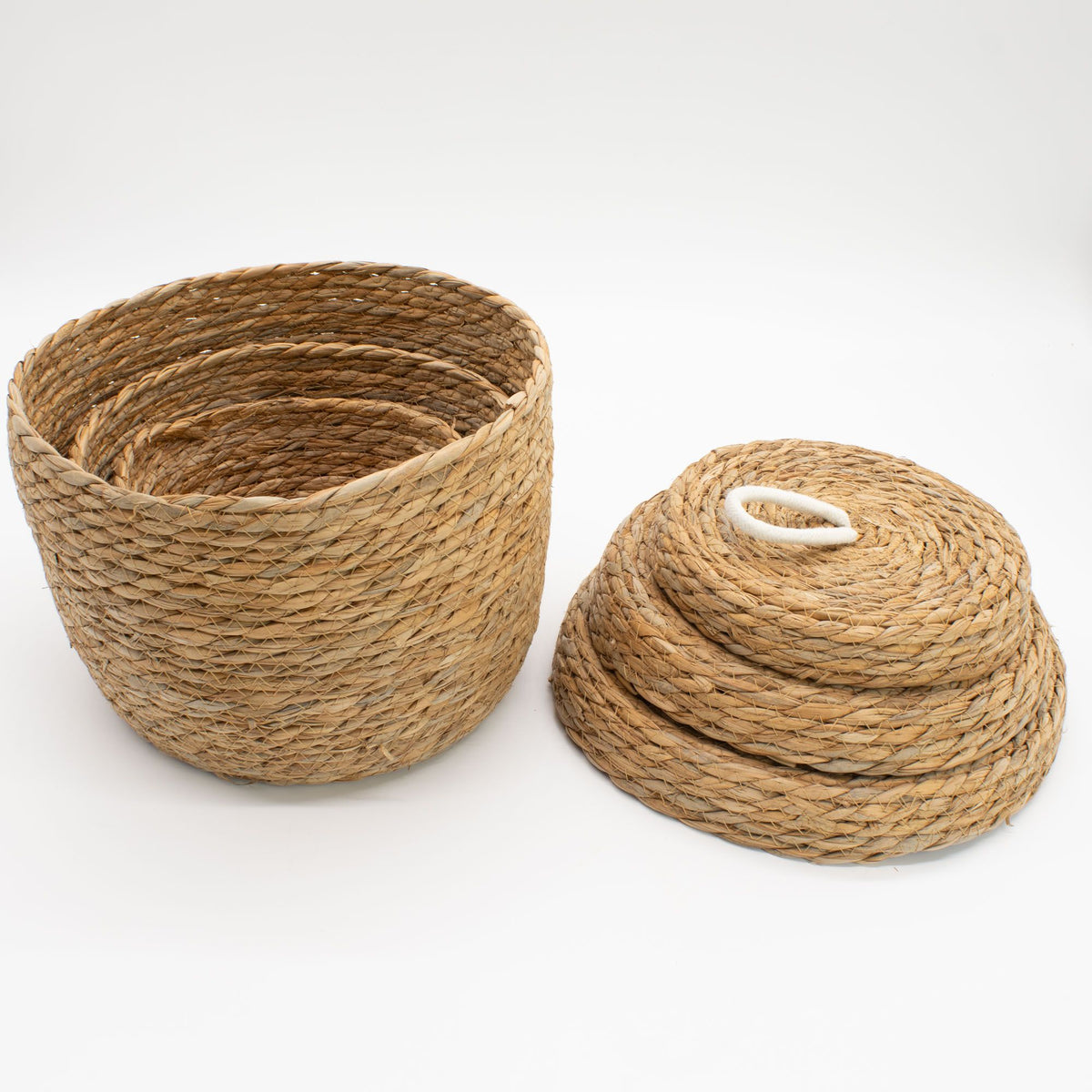 Two woven baskets made of natural material on a white background