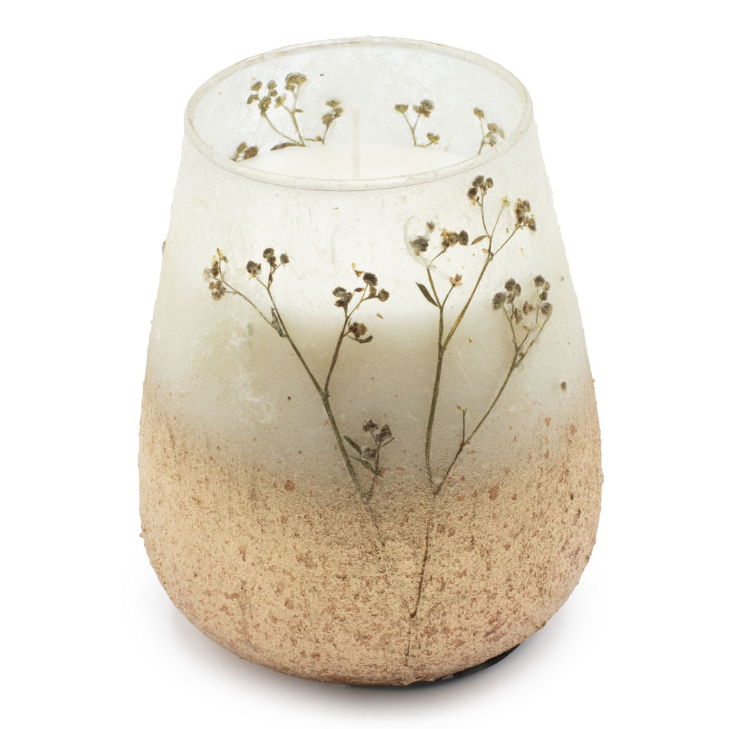 Glass candle holder with natural elements on a white background