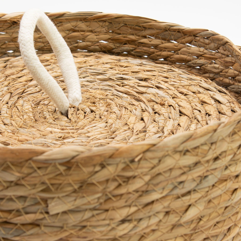 Close-up of a woven basket with a white rope handle.